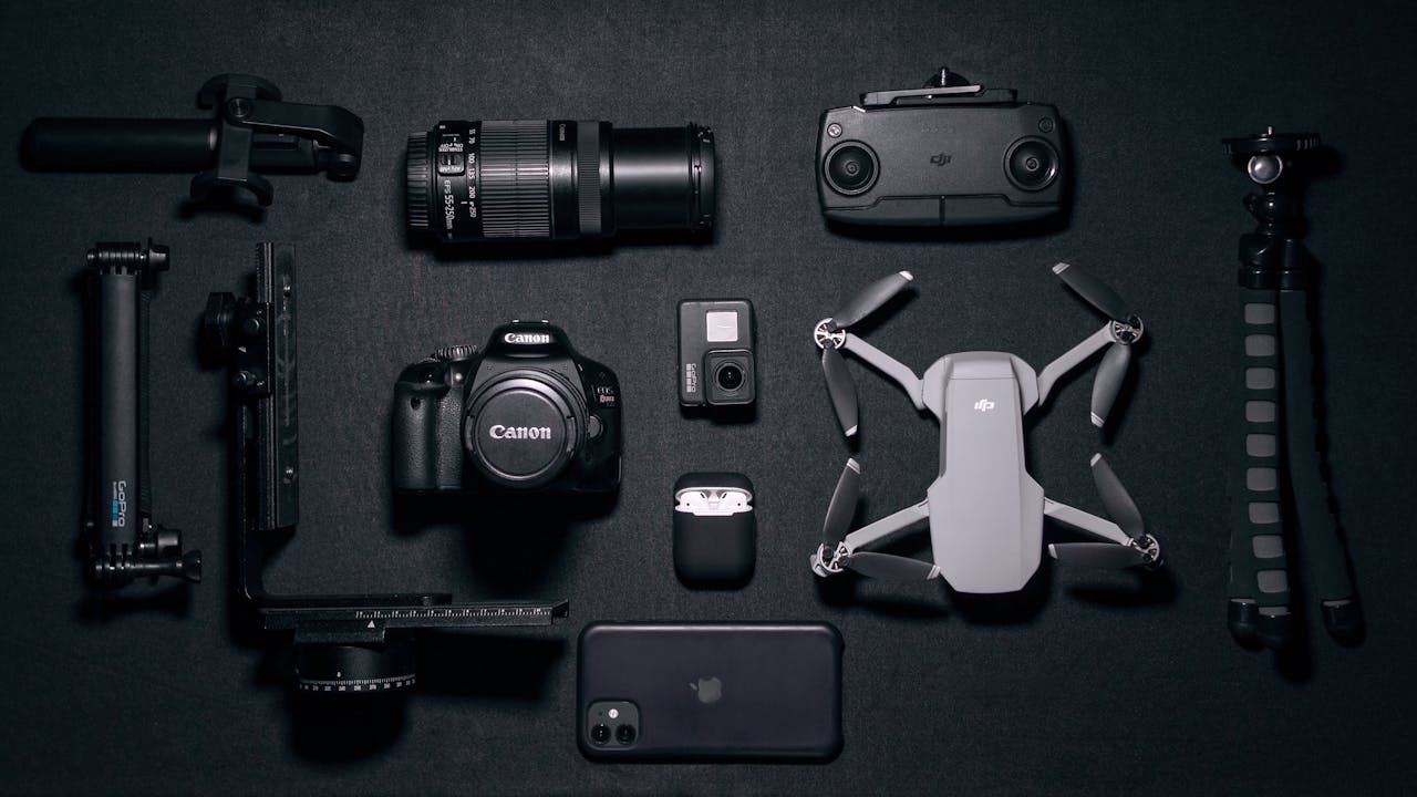 Aerial view of various photography and drone gadgets on a black surface.